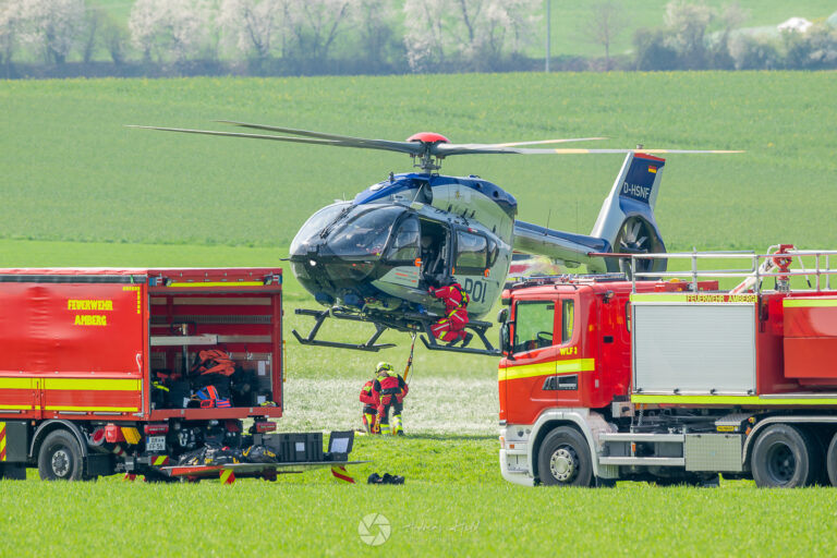 Feuerwehrleute, Fahrzeuge und Ausrüstung der Flughelfergruppe Amberg bei einer Übung zur luftunterstützten Brandbekämpfung mit Hubschraubern und Löschwasser-Außenlastbehältern.